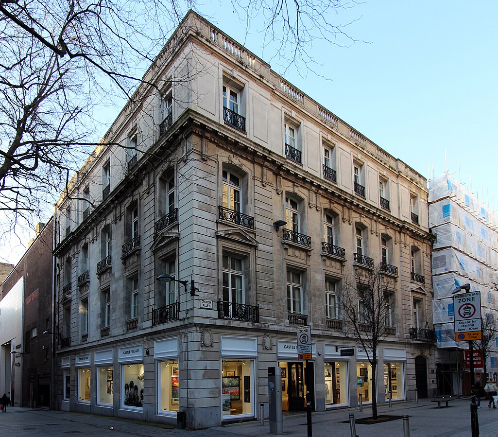 Full corner view of the Liverpool Athenaeum’s classical stone building on a pedestrian street.